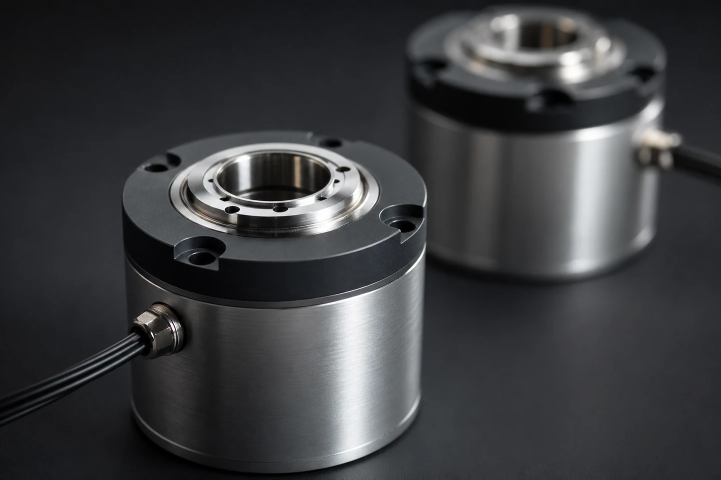 Precision-machined aluminum robotic joint housing on a dark studio surface